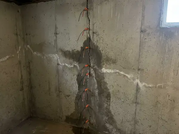 Scheur in een betonnen keldermuur met injectienippels