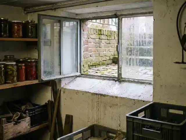 Open kelderraam met condensdruppels op de koude muur eronder